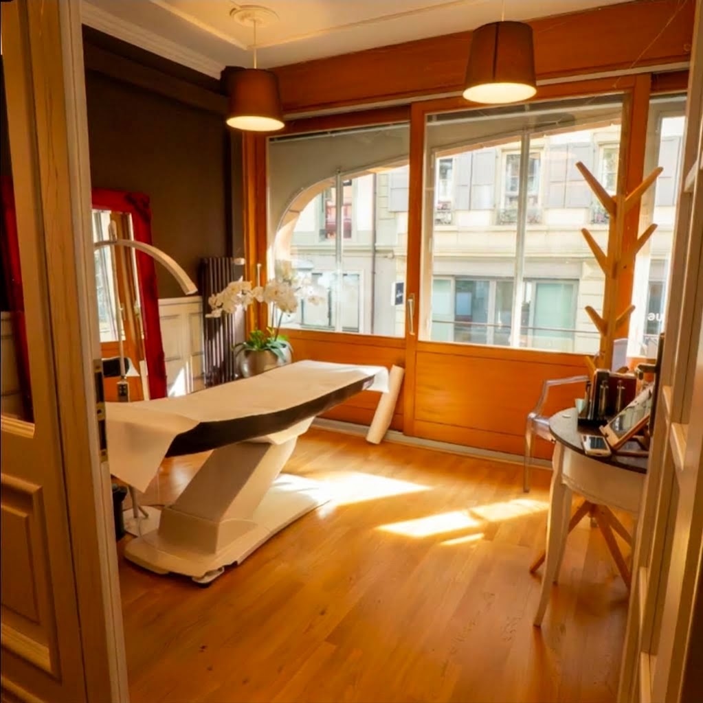 Cabine lumineuse du studio à Lausanne, avec table de soin et orchidée près de la fenêtre